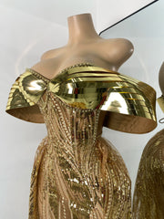 Gold dress with a unique design on a mannequin against a white background