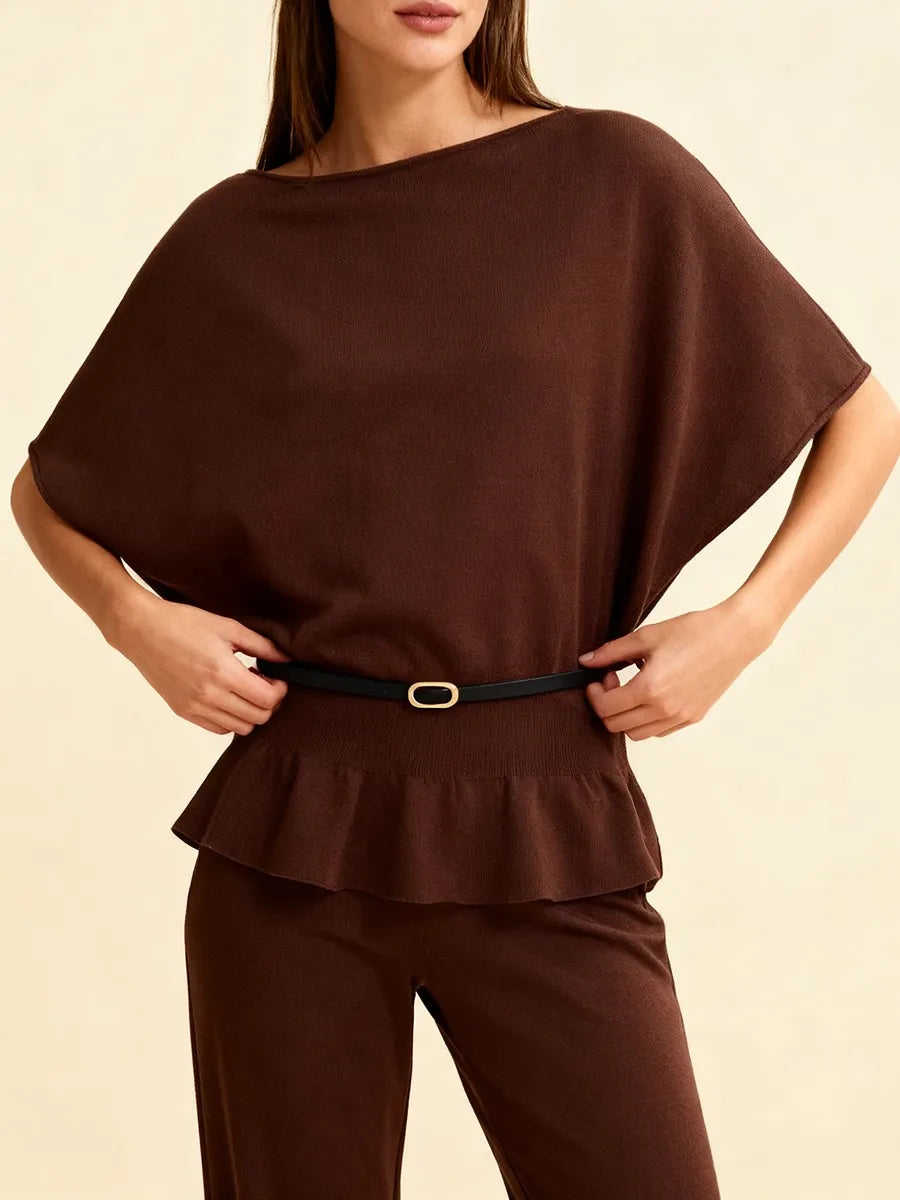 Brown peplum top and pants worn by a model on a beige background