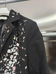 Black blazer with decorative patterns on a hanger