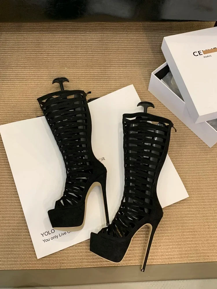 Black high-heeled shoes with a braided design on a textured surface with a box in the background.