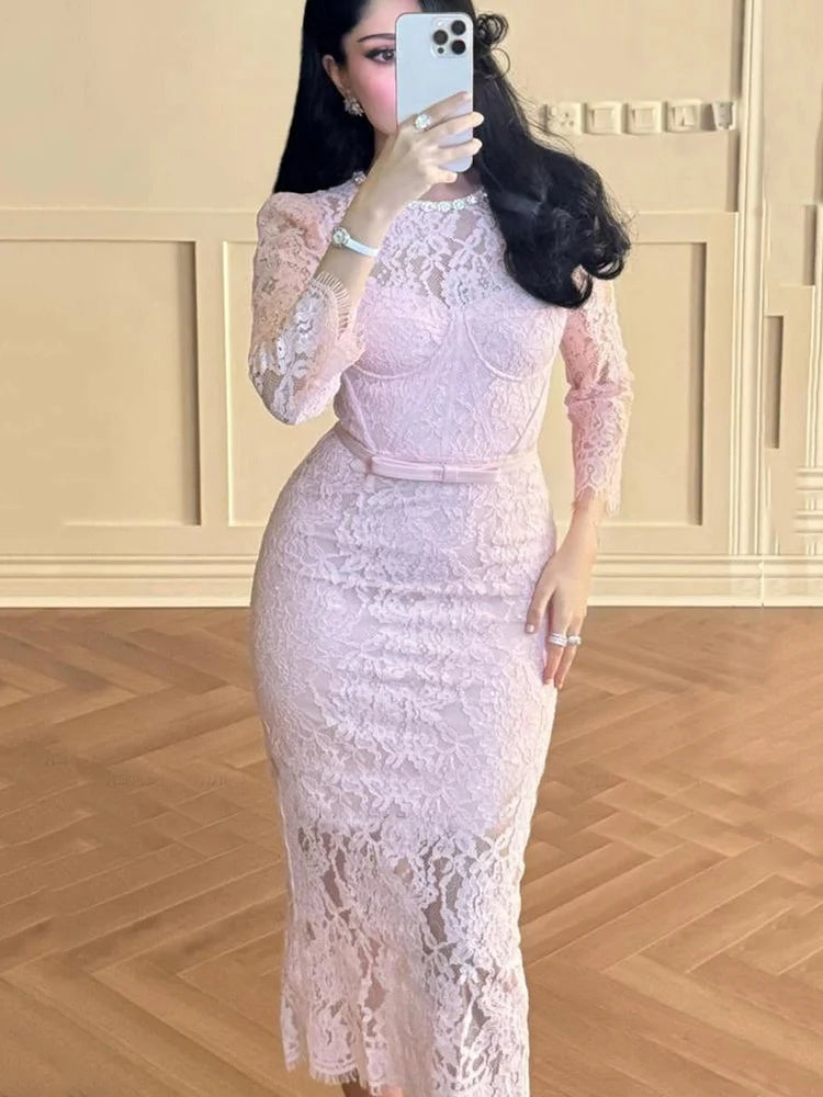 Person wearing a pink lace dress taking a mirror selfie.