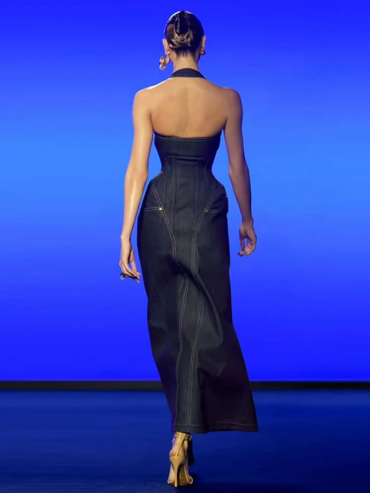 Woman wearing a black strapless gown against a blue background
