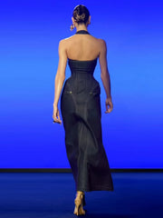 Woman wearing a black strapless gown against a blue background