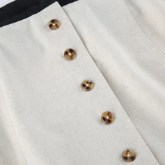 Close-up of a white fabric with gold buttons