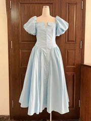 Light blue dress on a mannequin against a wooden door background