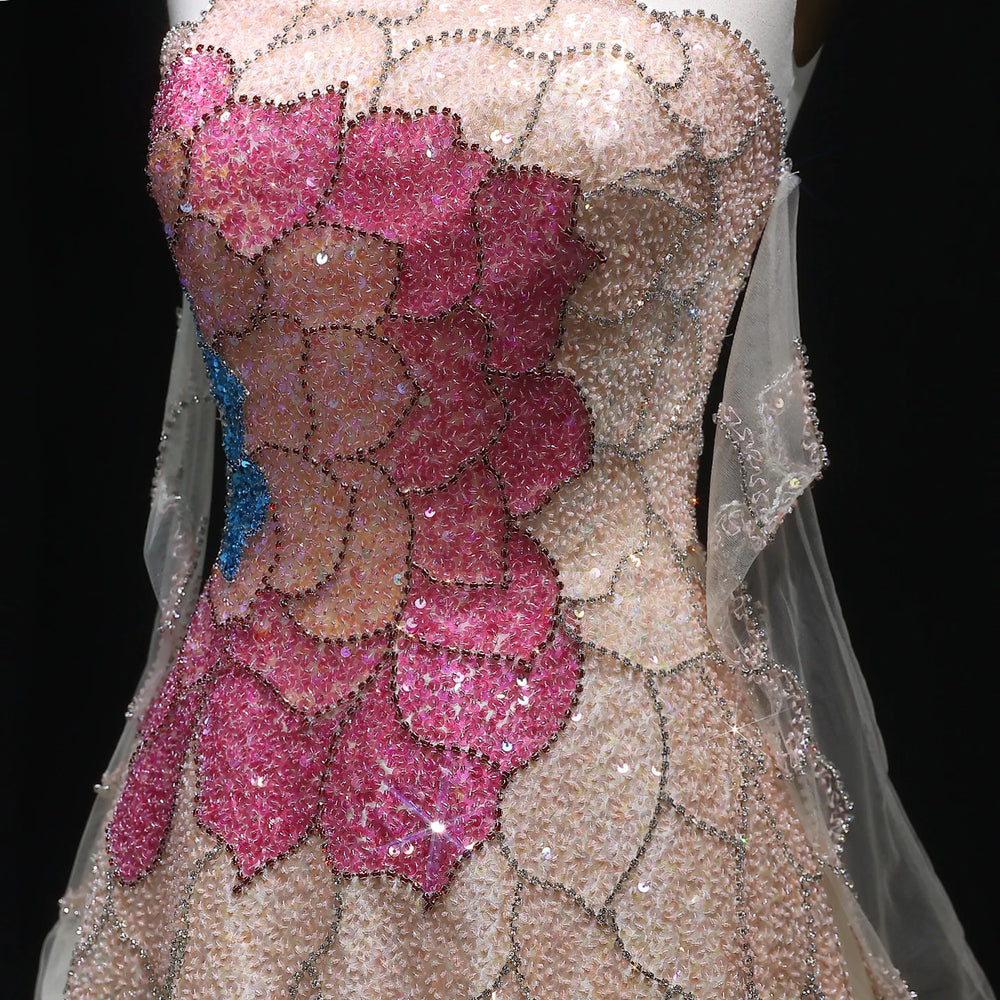 Close-up of a dress with pink floral embellishments and a black background