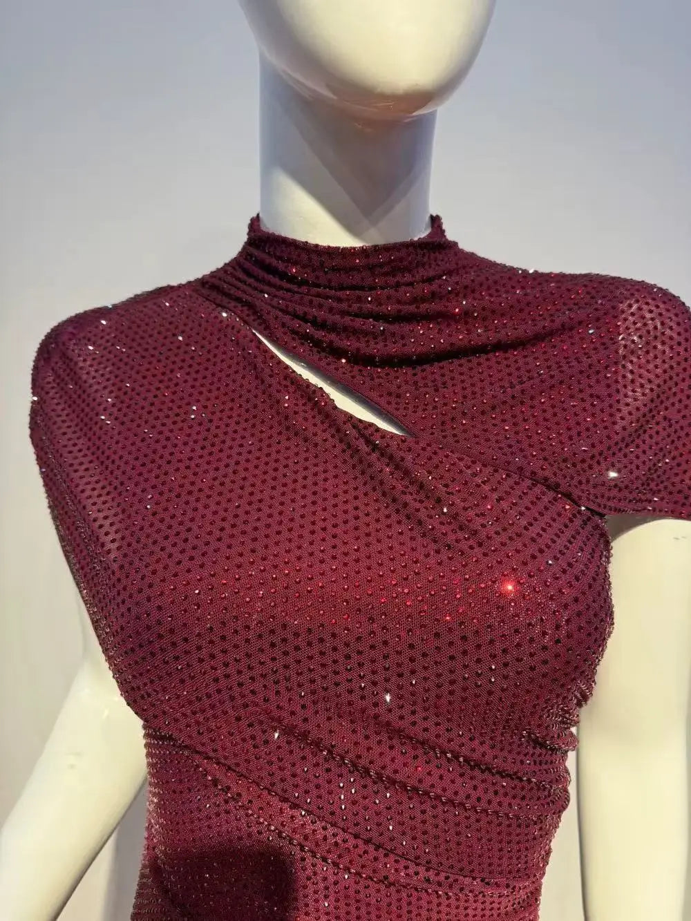 Burgundy sequin midi dress showing the detailed neckline and embellishments on a mannequin.