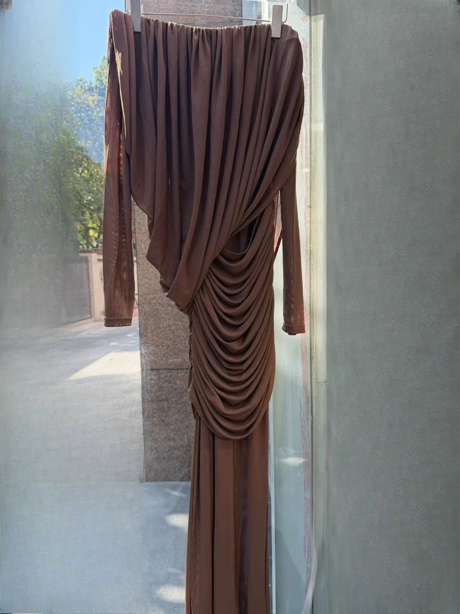 Brown draped dress hanging on a rack against a neutral background