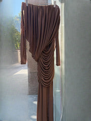 Brown draped dress hanging on a rack against a neutral background