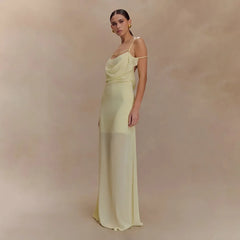 Woman wearing a light green evening gown against a beige background