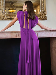 Woman in a purple evening gown standing in front of a mirror.