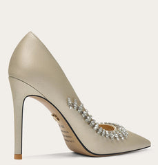 Beige high-heeled shoe with embellishments on a light gray background