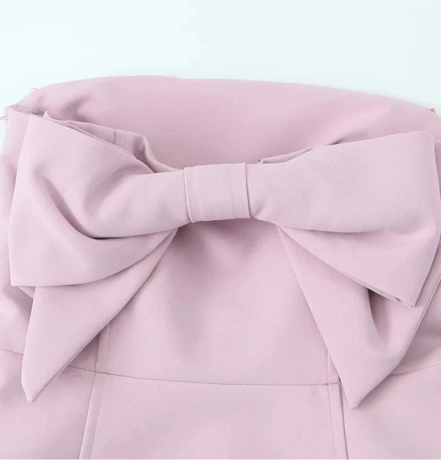 Pink dress with a large bow on a light gray background