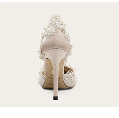 Beige high-heeled shoes with lace details on a white background