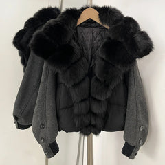 Black puffer jacket with fur trim on a hanger against a white background