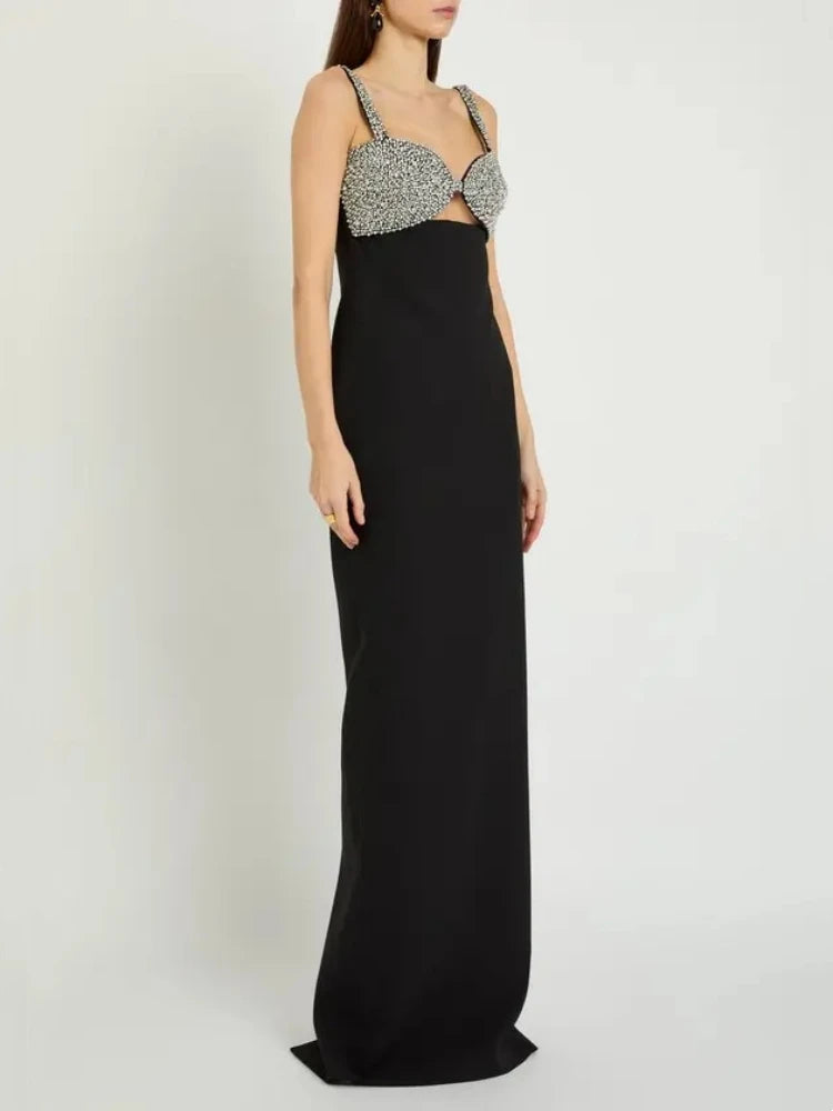 Black evening gown with a silver embellished top on a white background
