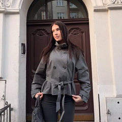 Close-up of a grey belted double-breasted trench coat