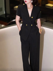 Person wearing a black suit with gold buttons in an indoor setting