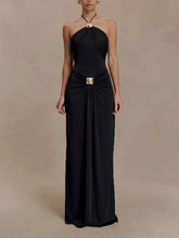 Black halter neck gown with a gold belt on a beige background