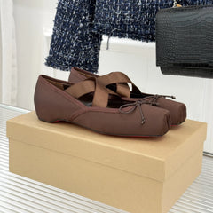 Brown ballet flats on a beige shoe box with a blurred background