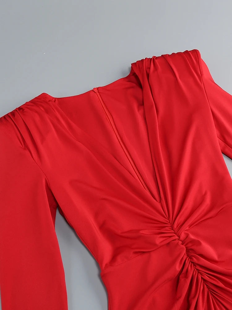 Red long-sleeve top with a knot detail on a gray background