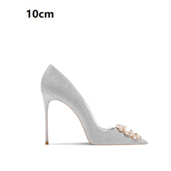 Silver high-heeled shoe with decorative elements on a white background