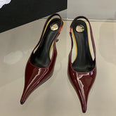 Pair of red high-heeled shoes on a reflective surface