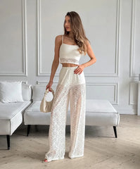 Woman in a white sequin outfit standing in a room with a neutral color scheme.