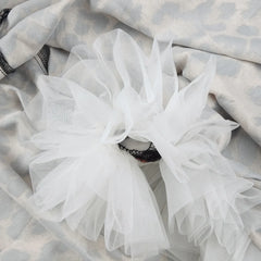 White tulle fabric on a textured gray background