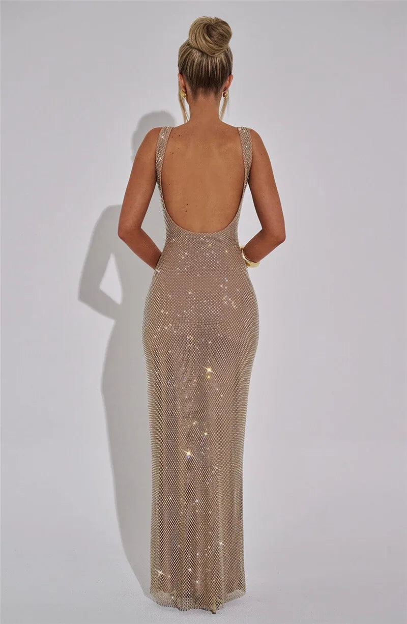 Woman wearing a sparkly, floor-length dress with a plain background