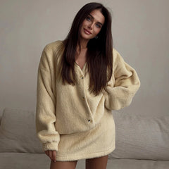 Woman wearing a beige oversized sweater in a neutral setting