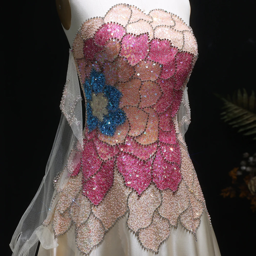 Close-up of a dress with pink and blue floral patterns and sequins.