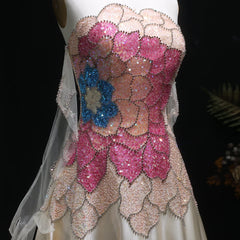 Close-up of a dress with pink and blue floral patterns and sequins.