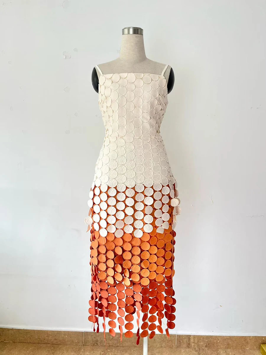 Dress on a mannequin with a white top and orange gradient skirt against a white background