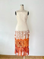 Dress on a mannequin with a white top and orange gradient skirt against a white background