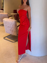 Woman wearing a red strapless dress with a slit in an indoor setting.