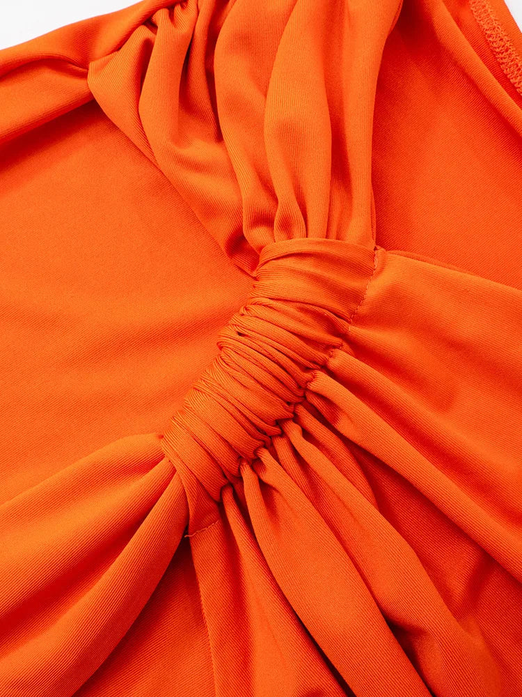 Close-up of an orange top with a gathered neckline.