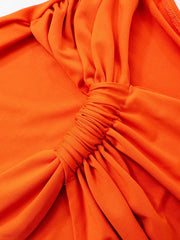 Close-up of an orange top with a gathered neckline.