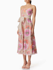 Woman wearing a floral strapless dress with a white background