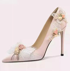 High-heeled shoe with floral decorations on a light pink background