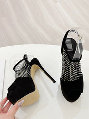 Black high-heeled shoes with rhinestone embellishments on a white surface.
