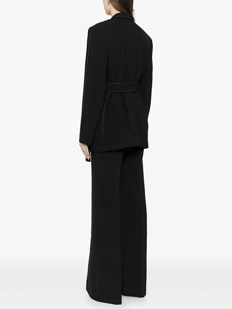 Black belted blazer and wide-leg pants suit with contrast stitching, shown from the back of a model.