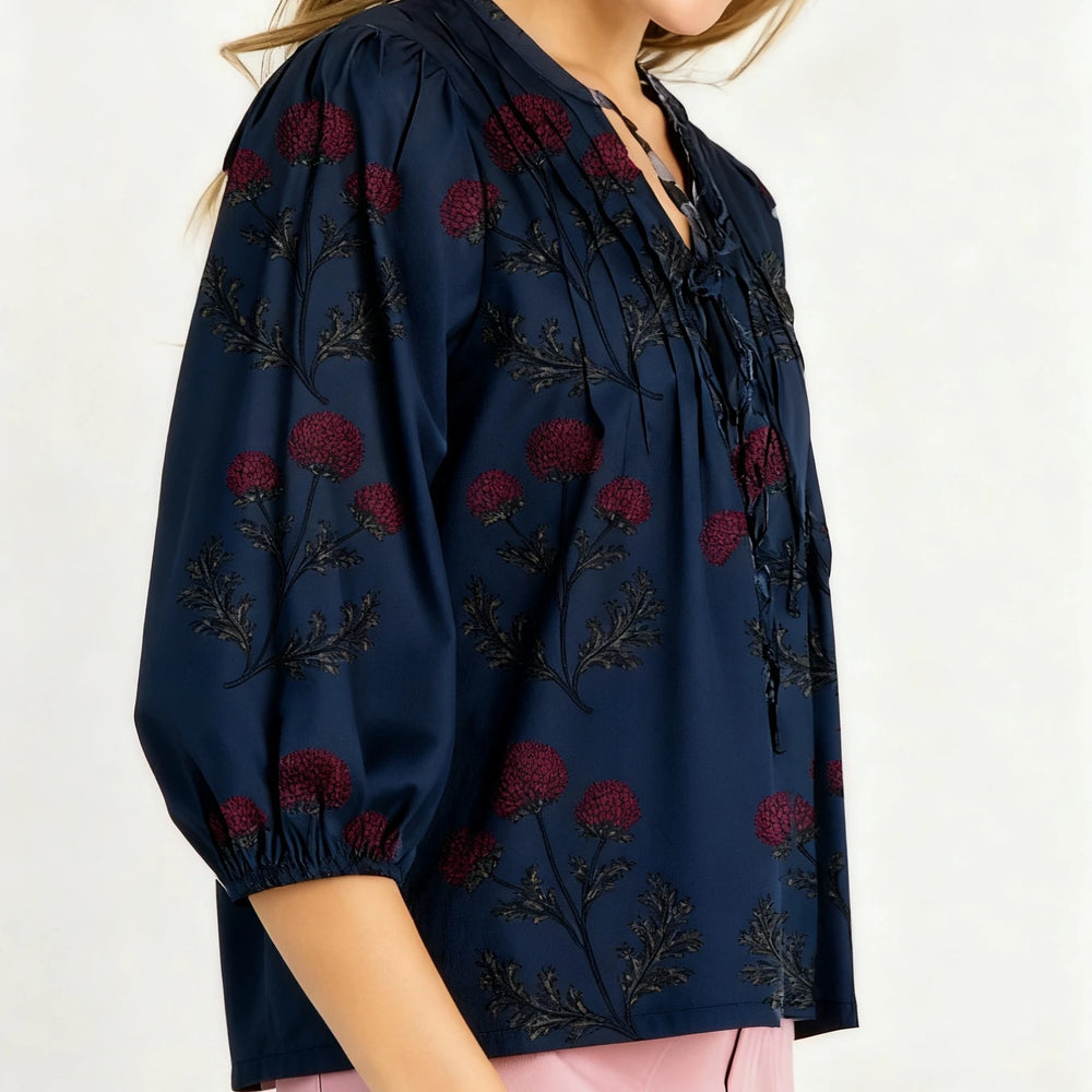 Navy blue blouse with red floral embroidery on a white background