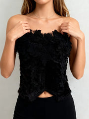 Black floral strapless top worn by a model against a plain background