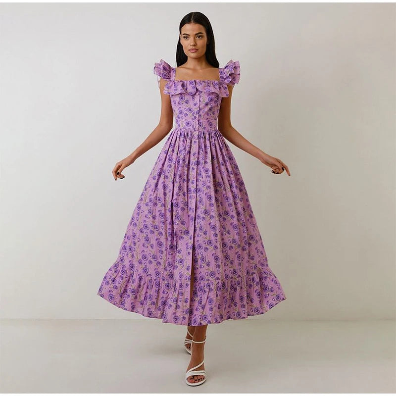 Woman wearing a purple floral dress against a plain background