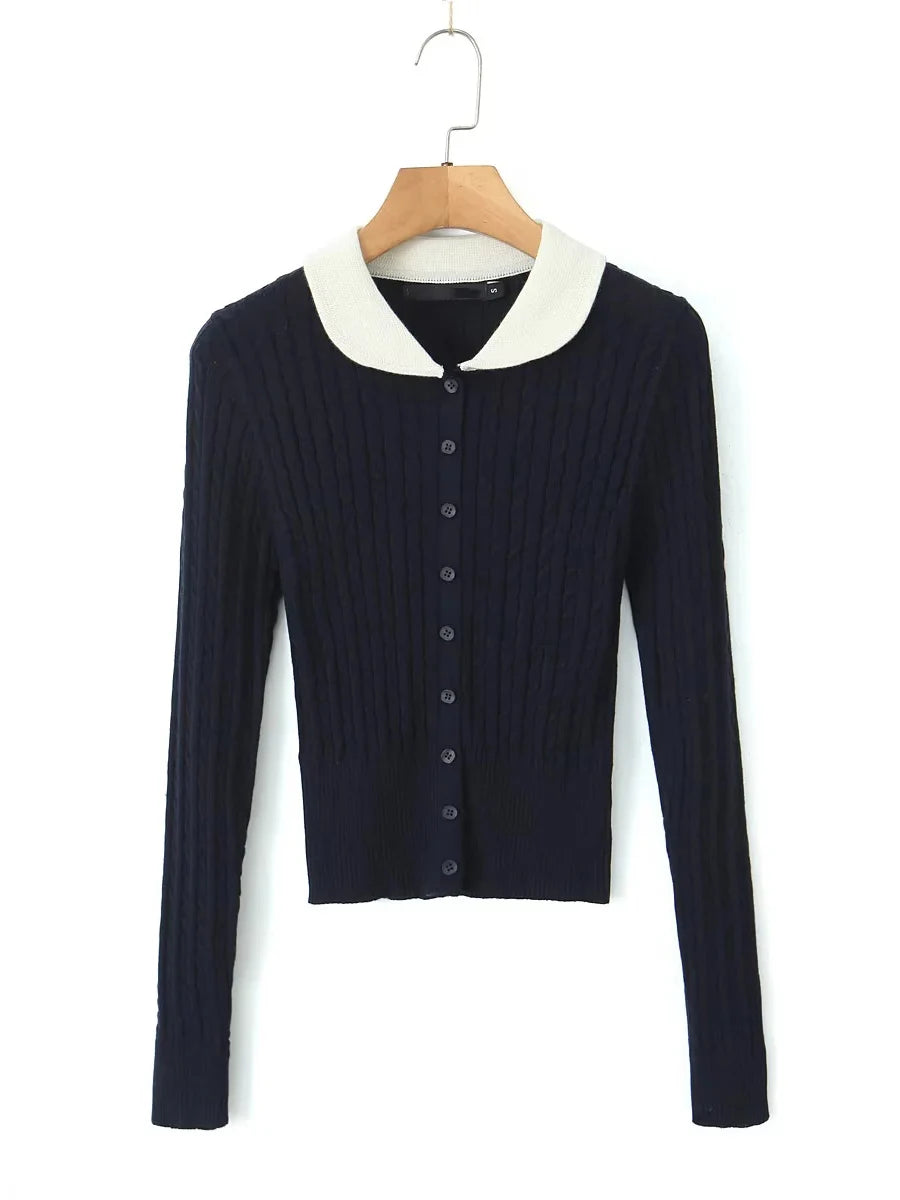 Navy blue sweater with white collar on a hanger against a white background
