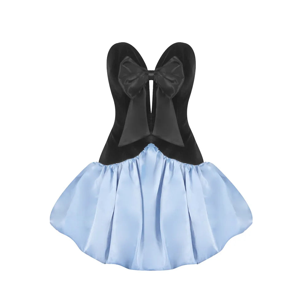 Black top with large bow and light blue skirt on a white background