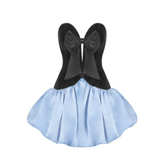 Black top with large bow and light blue skirt on a white background