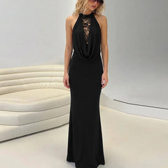 Woman wearing a black evening gown with lace detailing in a modern interior setting.