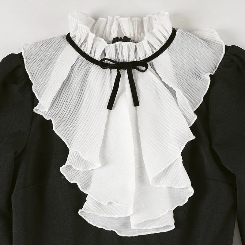 White ruffled collar with black trim on a black background